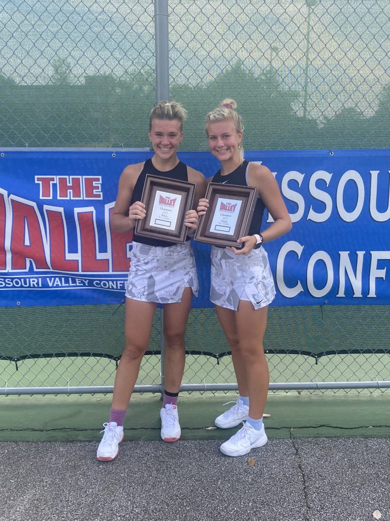 Olivia Czerwonka '23, '26 DNP, and Claire Czerwonka '21, '24 DNP, smiling and posing for a photo with both of their award plaques for winning the 2021 Missouri Valley Conference doubles championship.