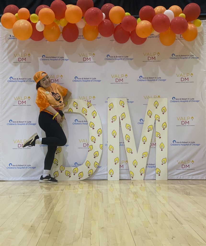 Reahlyn Bryce ’25 smiling and posing in front of photo backdrop at Valpo's Dance Marathon event.