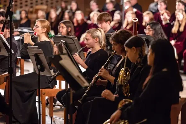 A group of musicians in black attire play woodwind instruments during a Music for Non-Majors concert performance.