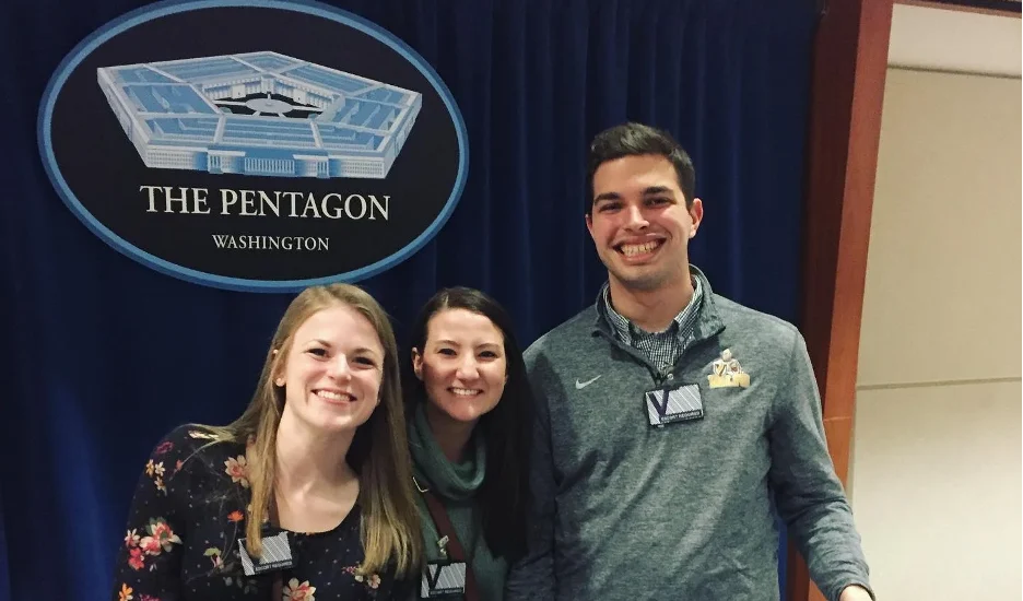 Three people smiling in front of a sign that says “The Pentagon Washington” with a blue background, capturing a memorable moment during their DEV semester in Washington D.C.