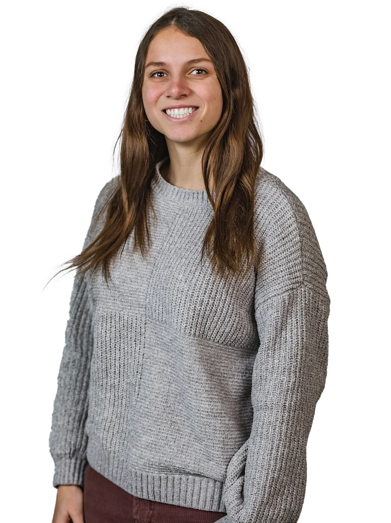 Peyton Evans, a woman with long brown hair, smiles in a gray sweater and maroon pants against a white background—showing why she’s the Right Choice at Valpo.
