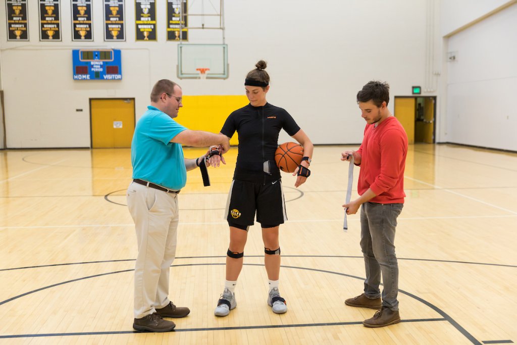 A basketball player at Valpo is the subject of a physical test administered by two bioengineering students.