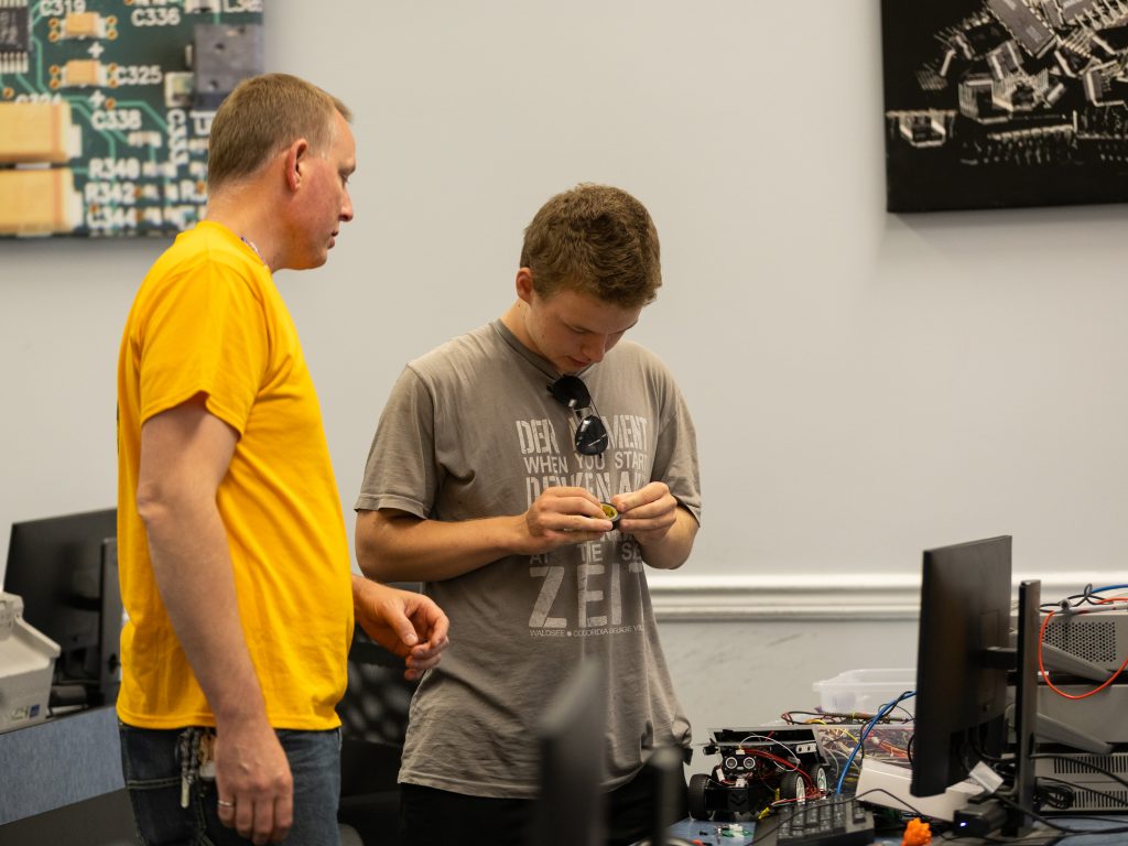 Camper working with Professor Dan White on the robotics project