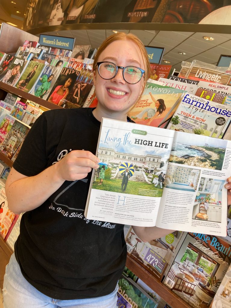 Cori Laatsch ’24 smiling while holding up a magazine featuring her article in a local Barnes and Noble bookstore.
