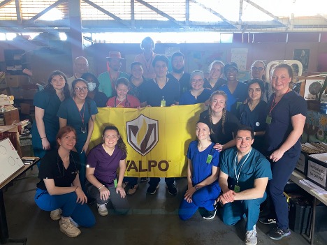 Valpo CONHP students and faculty posing with Valpo flag in Costa Rica.