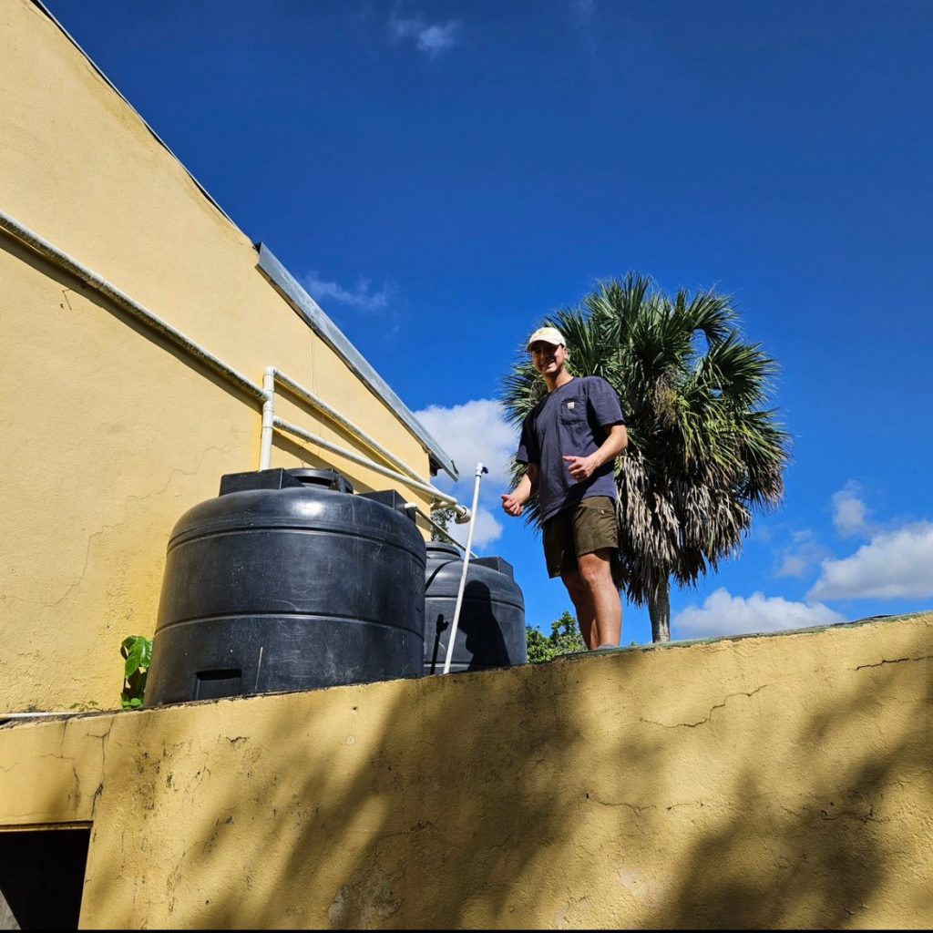 Teo Duran standing next to the UV water filtration in the Dominican Republic. 