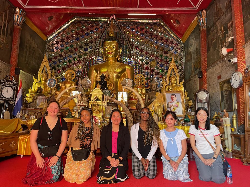 Valpo students kneeling in Thai temple. 