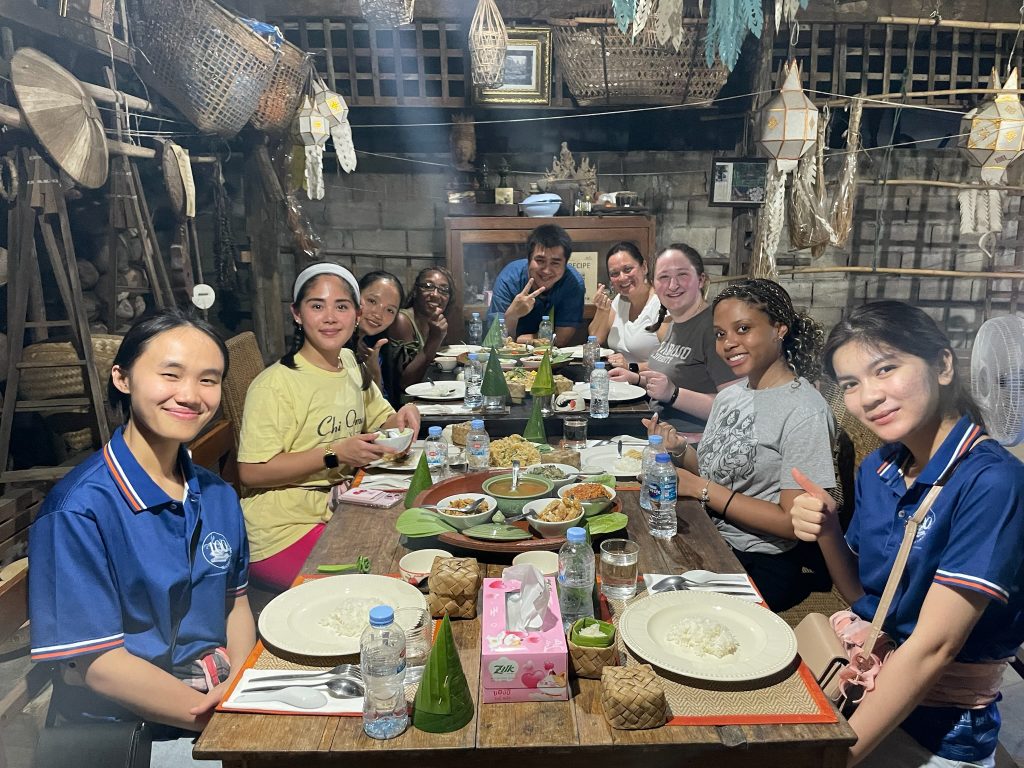 Thai students sitting at table eating in Thailand. 