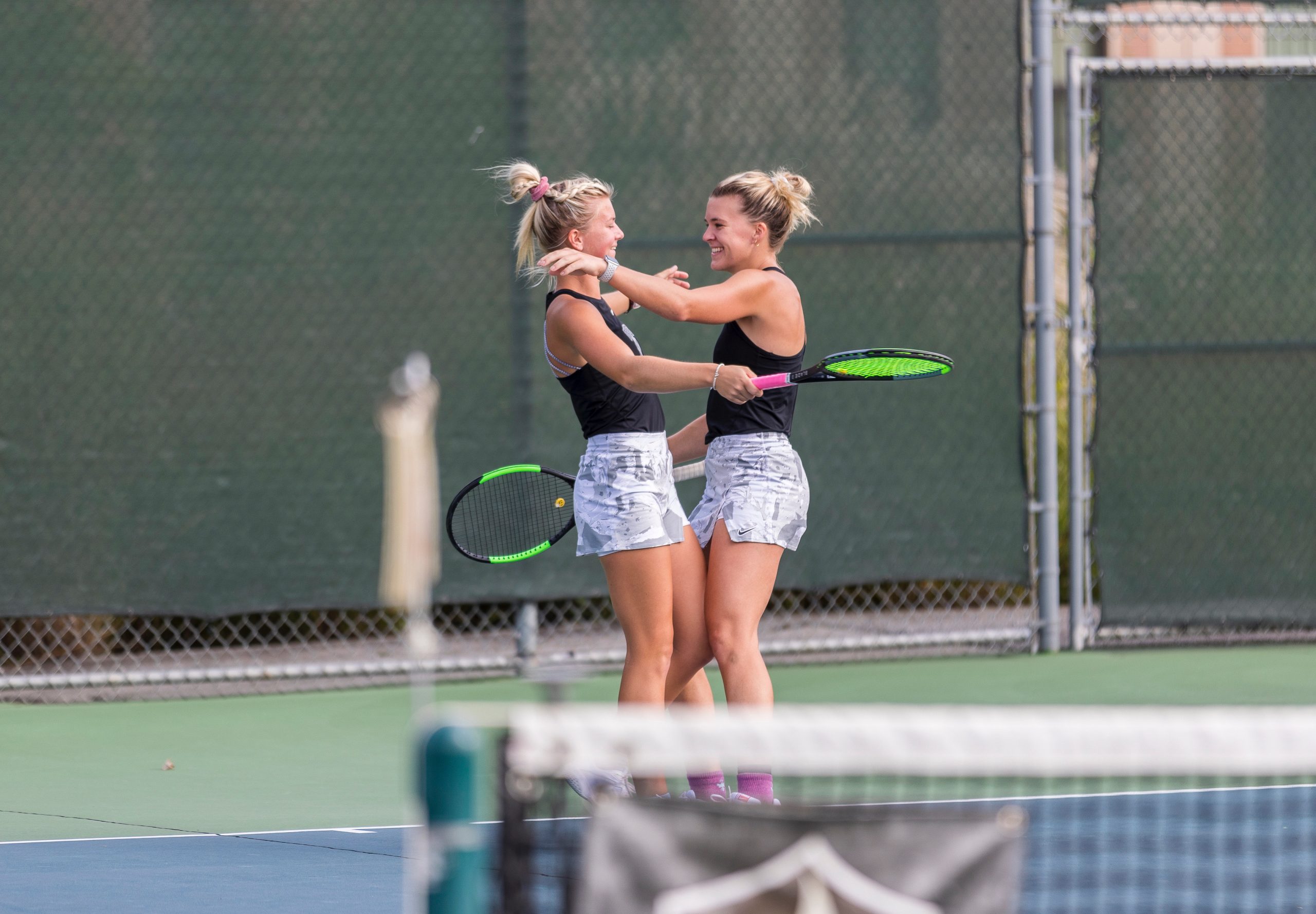 Olivia Czerwonka '23, '26 DNP, embracing her sister and doubles partner, Claire Czerwonka '21, '24 DNP, on Valpo's tennis court after a match.