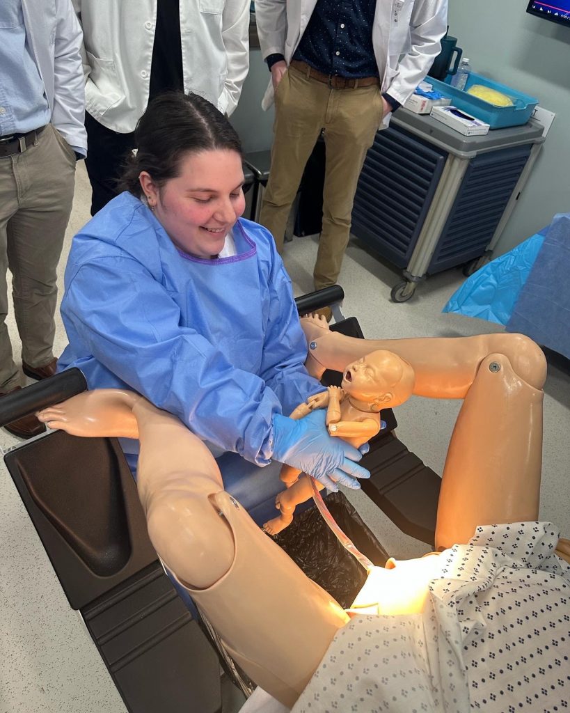 Female PA Student interacting with high fidelity mannequin.
