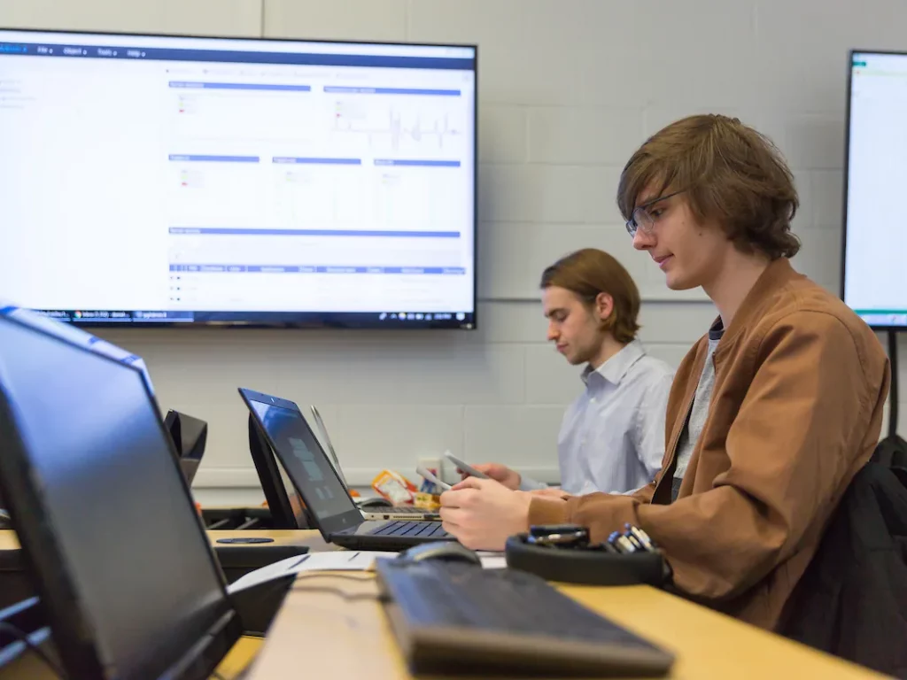 Two Valpo data science majors work at their laptops in class.