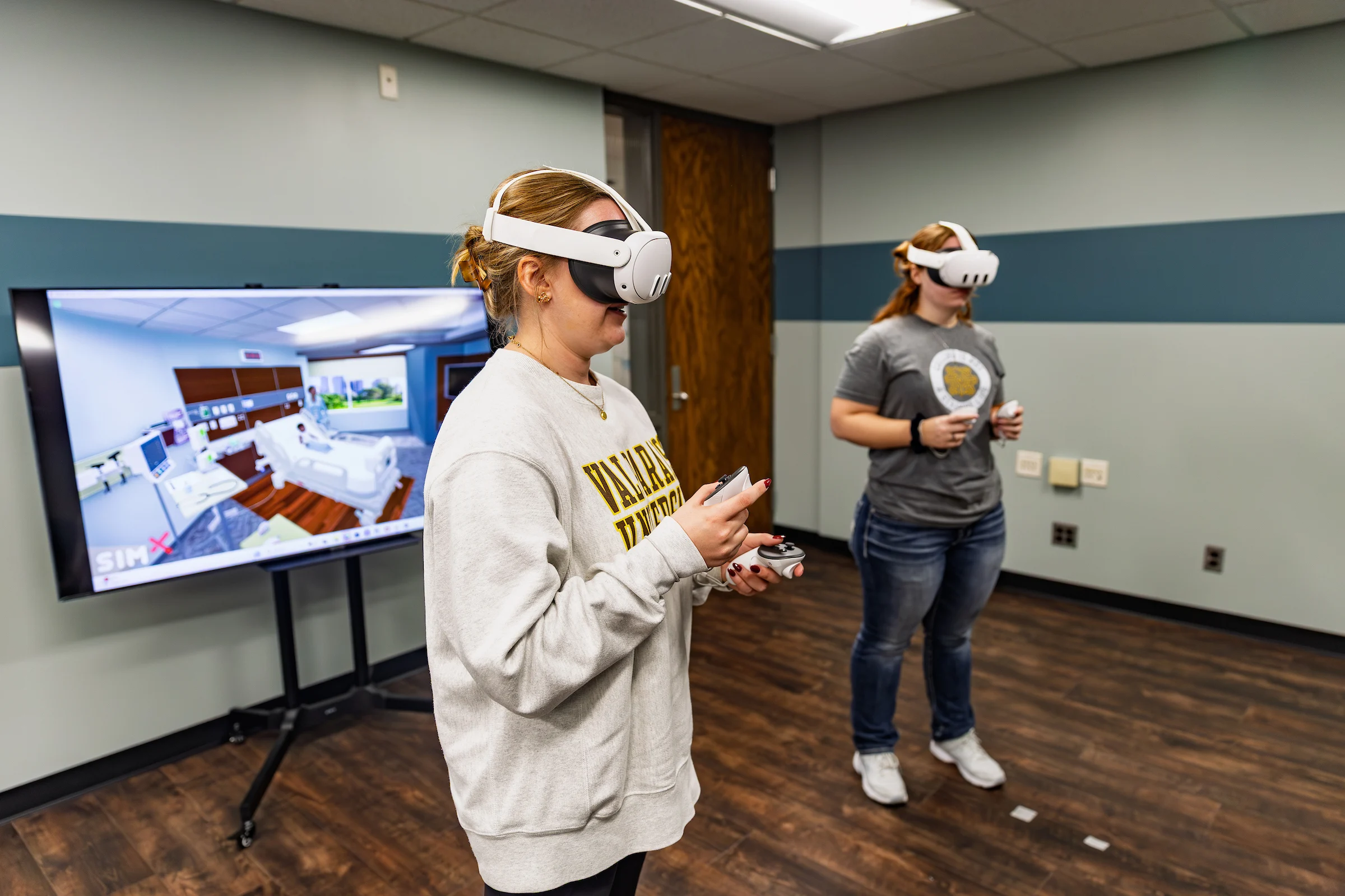 Two Valparaiso University nursing students wear virtual reality (VR) headsets and practice skills through VR training in Valpo's Center for Experiential Learning.