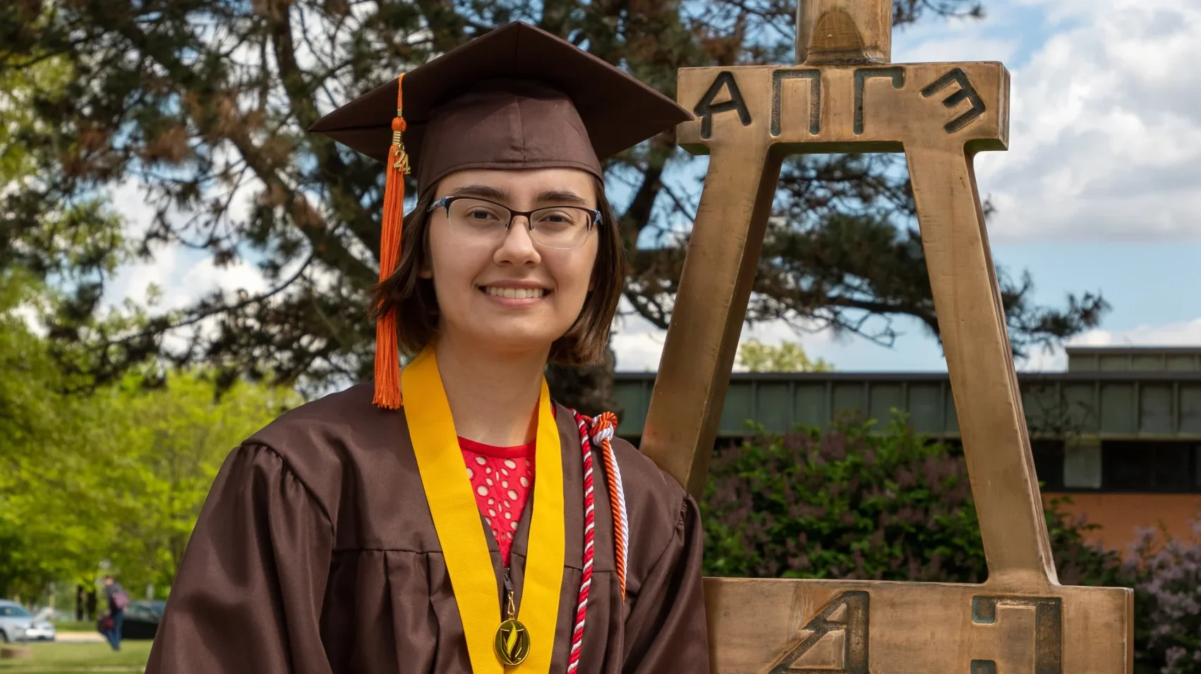 Valparaiso University alumna Adelle Holder smiles in her cap and gown after graduation on campus.