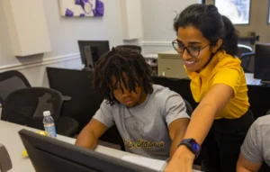 Valparaiso University classroom; both are focused on the screen, exploring concepts from the AI Practitioner Certificate.