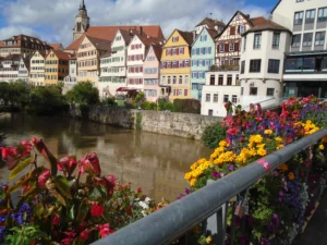 Colorful houses line a riverside, with vibrant flowers in the foreground on a sunny day—a scene reminiscent of the international learning opportunities available to engineering students at Valparaiso University.