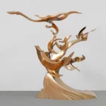 Abstract bronze sculpture with flowing, curved shapes resembling birds in flight on a textured base.