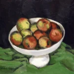 A white pedestal bowl filled with apples sits on a green cloth against a dark background.