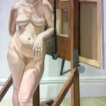 A nude woman leans against a large wooden artist's easel in a softly lit studio.