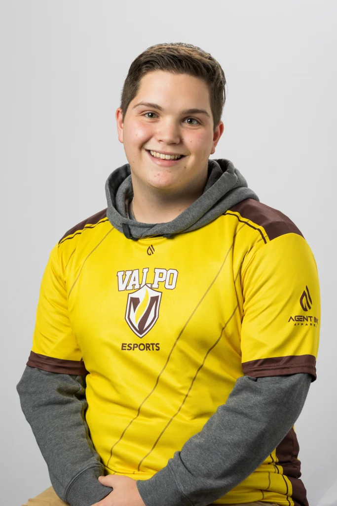 Smiling young person in a yellow Valpo Esports jersey, seated against a plain light background, looking ready for action—much like Daniel Murphy preparing weather forecasts.