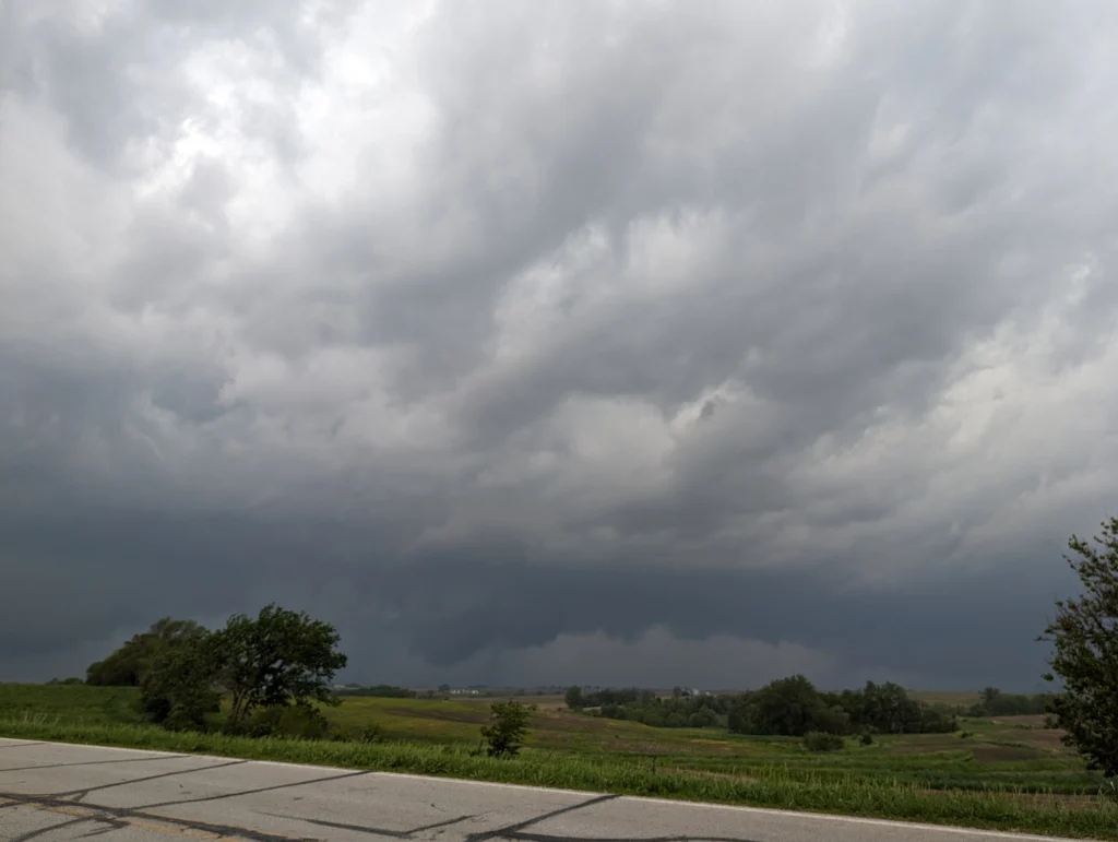 Dark storm clouds rolling over a rural landscape near Valparaiso University, with trees and fields beside a road, evoke an air of midnight mystery.