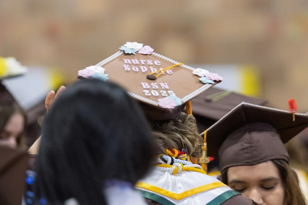 A graduation cap decorated with “nurse Sophie BSN 2025” and small flowers at a Valparaiso University graduation ceremony, celebrating future nurses ready to excel in the job market.