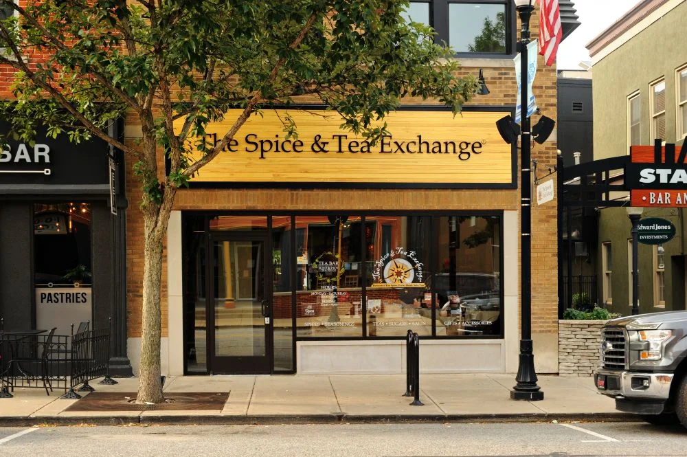 The Spice & Tea Exchange storefront in Beacon features a tree out front and a sidewalk along St. Aubin, inviting passersby to explore.