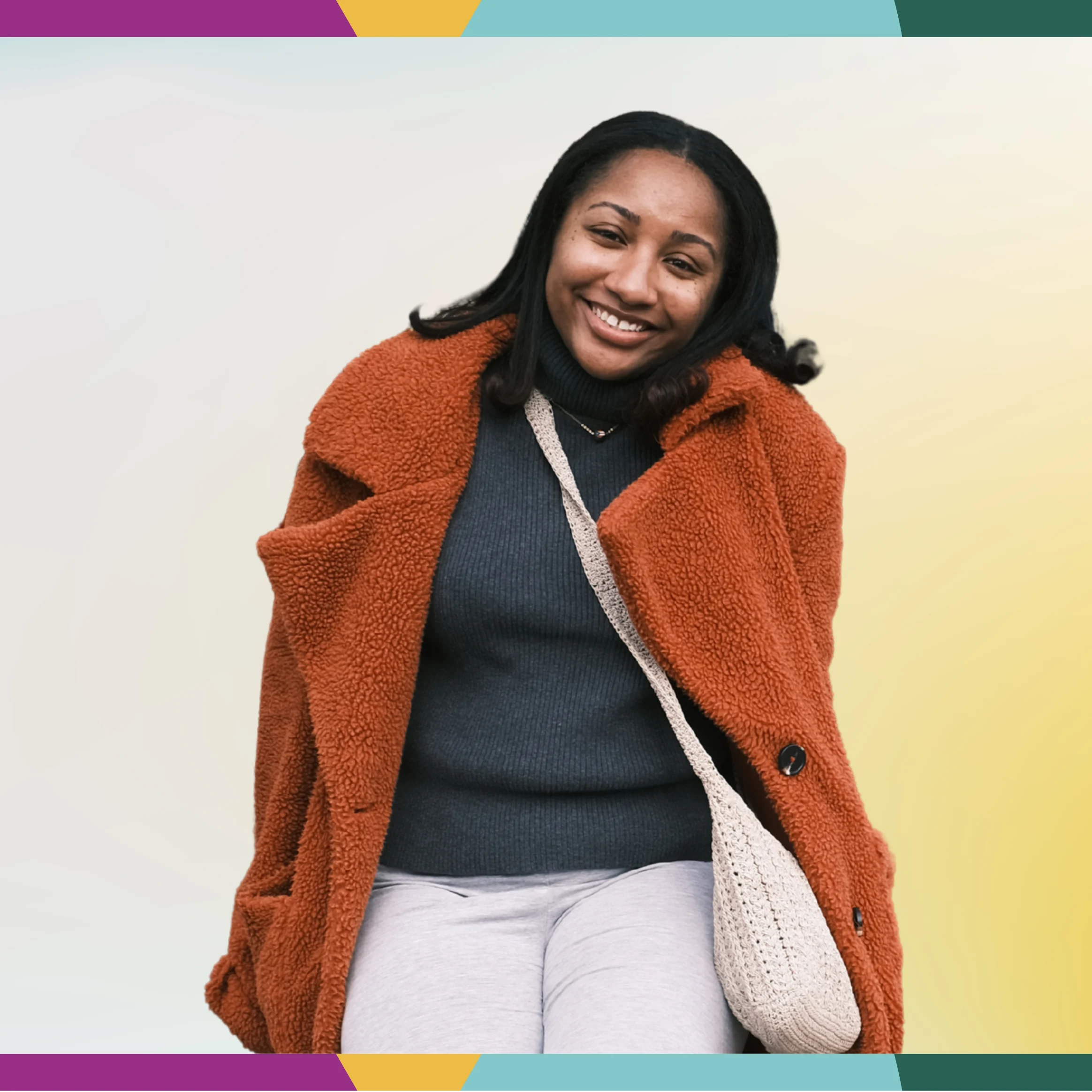 Smiling multicultural woman in an orange coat and gray outfit, sitting against a pastel background with a colorful border, truly in the spotlight.