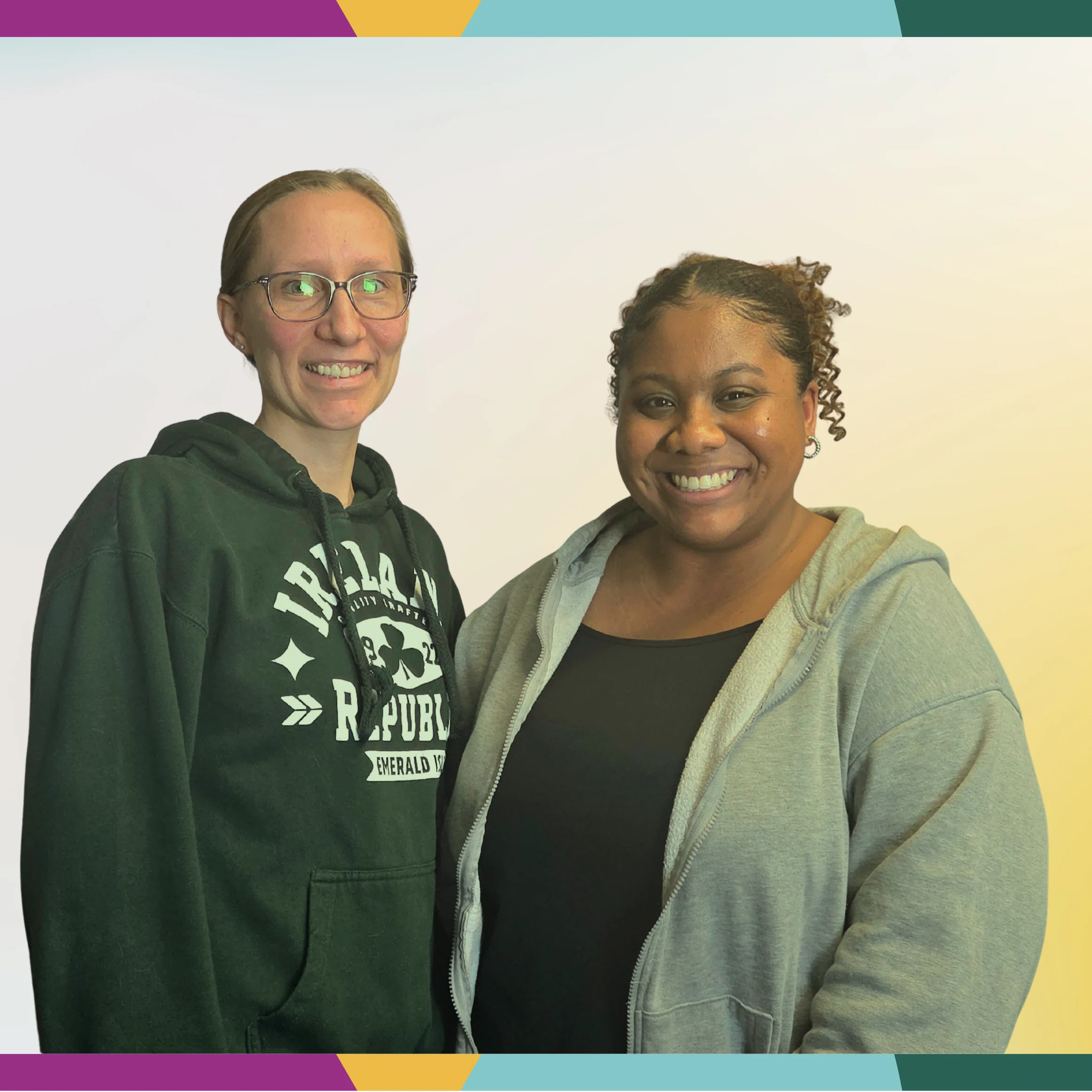 Two women smiling at the camera, standing side by side in casual clothing against a light background, are featured in this Multicultural Spotlight.