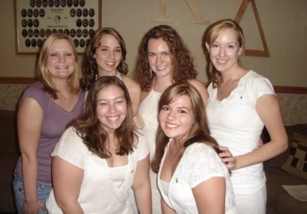 Five women, some wearing white and one in purple, smile and pose together indoors in front of wall decor at Beacon, joined by Meredith Garofalo.