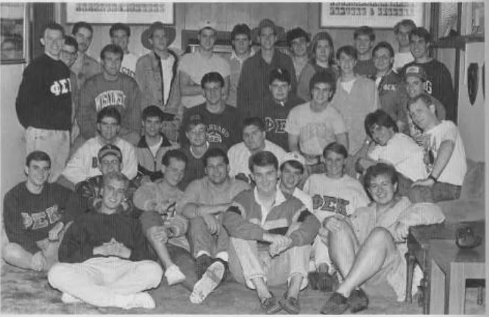 A group of Beacon alumni, including Chris Hanson, in casual clothes pose together in a room for a black and white group photo.
