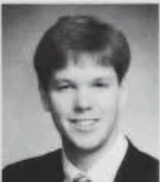 Black and white portrait of Chris Hanson, a young man in a suit, smiling at the camera—a true beacon of confidence and charm.