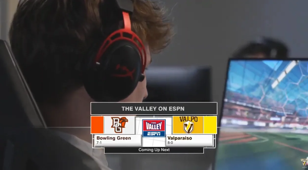 A person with headphones faces a screen, immersed in the upcoming Bowling Green vs Valparaiso esports match airing soon on ESPN.