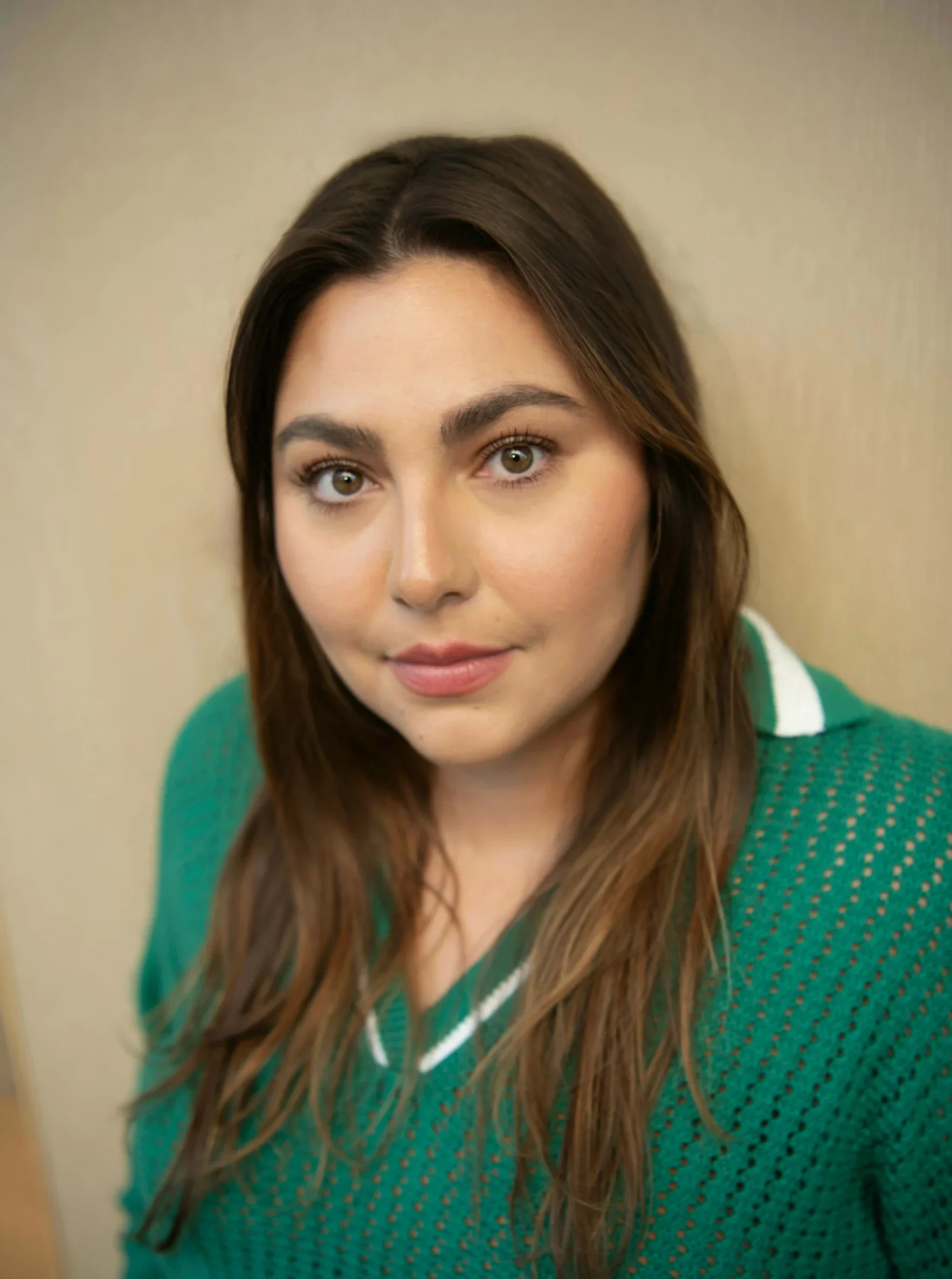 Nicole Lachat with long brown hair wearing a green collared sweater.