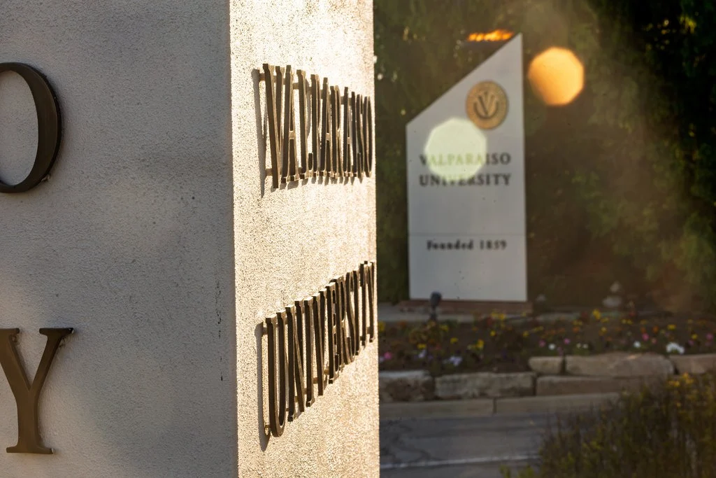 Valparaiso University monument sign with sunlight and greenery in the background, showcasing the campus’s dedication to values-driven education through initiatives like the Educating Character Initiative, made possible by an Institutional Impact Grant.
