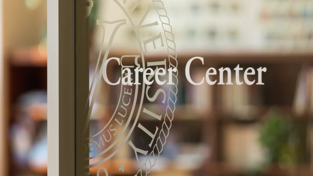 Career Center sign on a glass door with a university seal, providing career guidance.