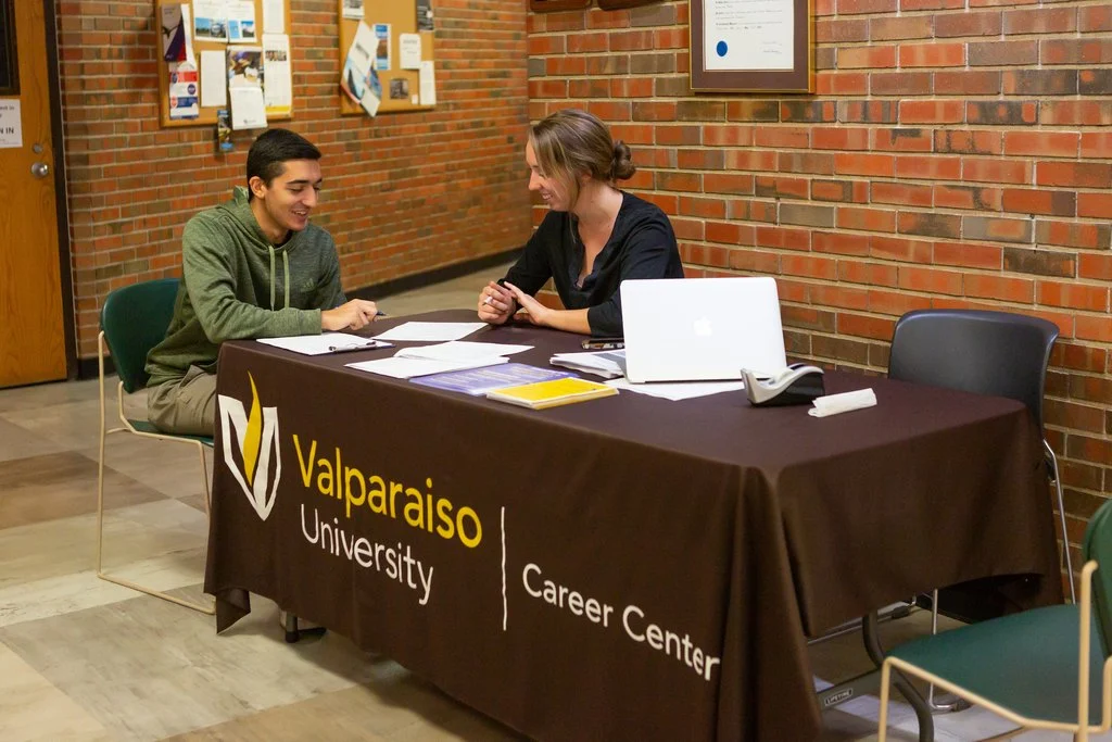 A student and Career Center staff member sit at a Valparaiso University table discussing career readiness.