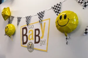 Sign reading “Go BaBy go!” with smiley balloons and checkered bunting at a Valparaiso University Collaboration Challenge.