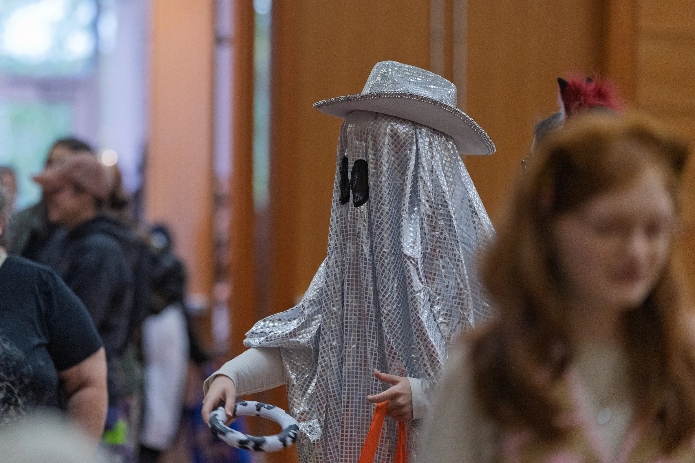 A person in a silver holographic ghost costume and cowboy hat at a Valparaiso University Halloween event.